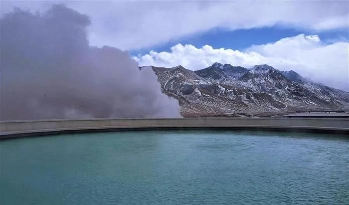 西藏自治区拉萨市羊八井的一处温泉和远处的雪山