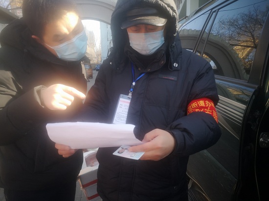 2市科协值班人员对进入社区的业主测量体温，登记详细信息.jpg